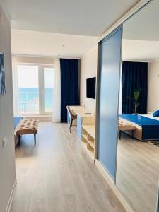 een hotelkamer met een slaapkamer met een bed en een bureau bij KIR House On The Beach in Eforie Nord