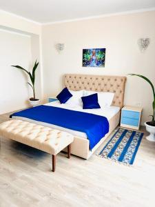 a bedroom with a large bed and a bench in it at KIR House On The Beach in Eforie Nord