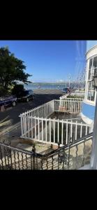 een wit hek voor een gebouw en het strand bij Lantana Guest House in Weymouth