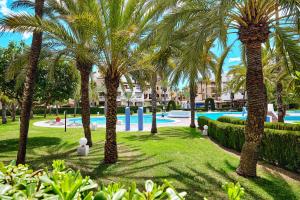 un parque con palmeras y una piscina en Apartamento Aldea del Mar, en Torrevieja