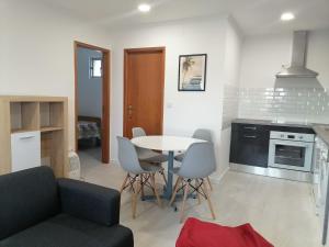 a kitchen and living room with a table and chairs at Lourisol in Lourinhã