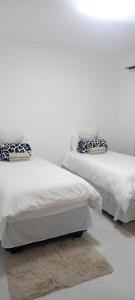 dos camas sentadas una al lado de la otra en un dormitorio en Esteem Guesthouse, en Okakarara