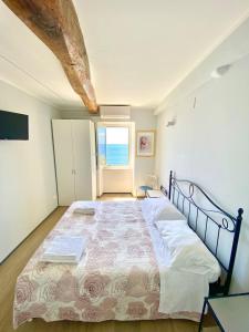 a bedroom with a large bed with a large window at Apartment La Scogliera - Riomaggiore in Riomaggiore