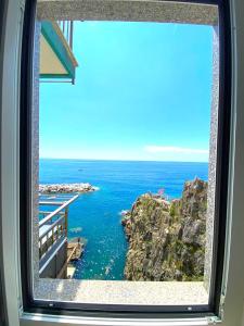 a view of the ocean from a window at Apartment La Scogliera - Riomaggiore in Riomaggiore +12 photos