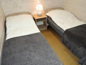 two beds in a room with a lamp on a table at New holiday homes for 2 people in Dziwnówek in Dziwnówek