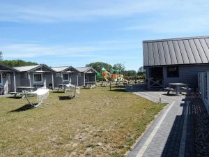 a row of houses with a yard with chairs and a building at New holiday homes for 2 people in Dziwnówek in Dziwnówek
