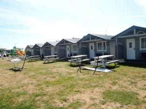 a row of beach huts with picnic tables in a yard at New holiday homes for 3 people in Dziwnówek in Dziwnówek