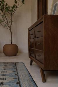 a wooden dresser with a potted plant in a room at Narrativ Lofts - Numen - Stylish Hideaway in Campeche