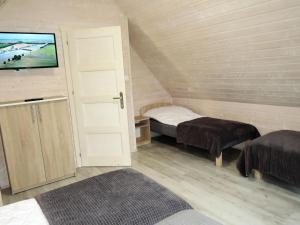 a room with two beds and a flat screen tv at Holiday Home in Dziwnówek by Sea and Lake in Dziwnówek