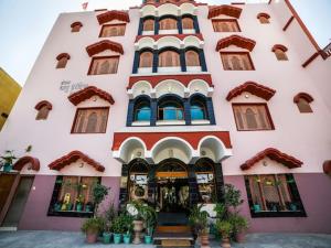 a large building with many windows and plants in front of it at hotel babu heritage in Bikaner