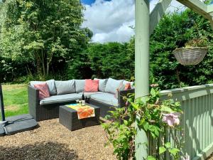 a patio with a couch and a table at Delightful 1 bed, 1 bath Norfolk Broads Guesthouse in Halvergate