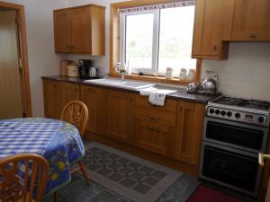 a kitchen with wooden cabinets and a table and a window at Loneacre in Wick