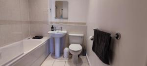 ein Badezimmer mit einem Waschbecken, einem WC und einer Badewanne in der Unterkunft ExCel Exhibition Center Apartment in London