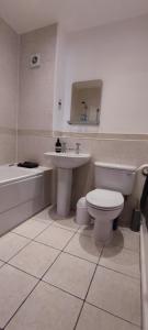 a bathroom with a toilet and a sink and a tub at ExCel Exhibition Center Apartment in London