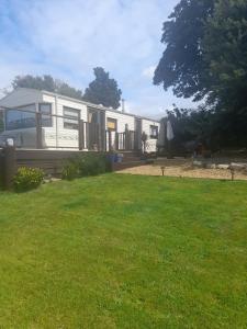 a mobile home in a yard with green grass at Gilfach in Clynnog-fawr