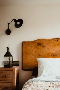 1 dormitorio con 1 cama con cabecero de madera y lámpara en Baiolei en Azpeitia