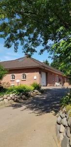 a red brick building with a driveway in front of it at Nordsee Ferienwohnung im Künstlerhaus bei Husum - keine Monteure Arbeiter in Oldersbek