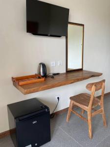 uma prateleira na parede com uma televisão e uma cadeira em Kasapa Inn em Ubud