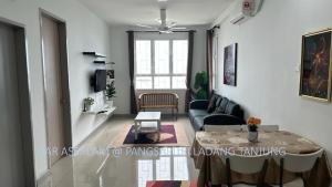 uma sala de estar com uma mesa e um sofá em Ladang Tanjung Dar Assalam Homestay em Kuala Terengganu