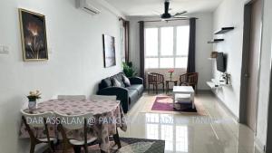 uma sala de estar com uma mesa e um sofá em Ladang Tanjung Dar Assalam Homestay em Kuala Terengganu