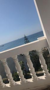 a white railing with a view of the ocean at Inviting 1-Bed Apartment in Ksar sghir in Ksar es Sghir