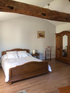 - une chambre avec un grand lit et une commode en bois dans l'établissement Château Laborde Caudalie, à Saint-Médard-de-Guizières