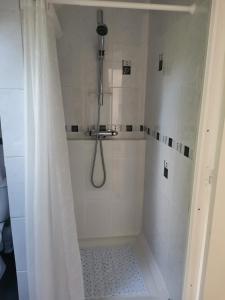 een badkamer met een douche en een douchegordijn bij Chambre double avec salle de bains privative in Moyon