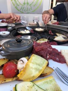 a table full of food with meat and other foods at Hôtel Génépi in Beuil