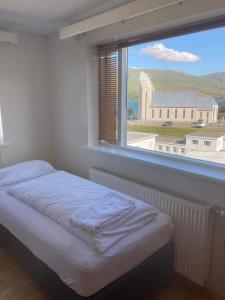 a bedroom with a bed and a large window at Central by the Church *Family Villa in Akureyri