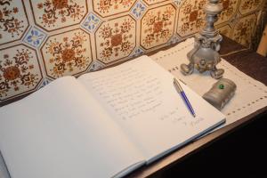 ein offenes Notizbuch mit einem Stift auf dem Tisch in der Unterkunft Palace Museum - Espaço Palmeiras in Porto