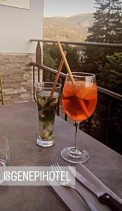 a drink and a glass on a table at Hôtel Génépi in Beuil