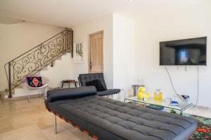 un soggiorno con un grande divano e una scala di Villa Aprile a Saint-Étienne-du-Grès