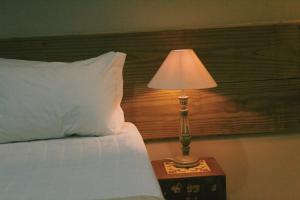 a lamp on a night stand next to a bed at Pousada Fruta Pão in Barra Grande