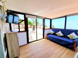 a living room with a blue couch and a flat screen tv at Casa Rural Giovanni & Rosa B Icod de los Vinos by HRTenerife Net in Icod de los Vinos