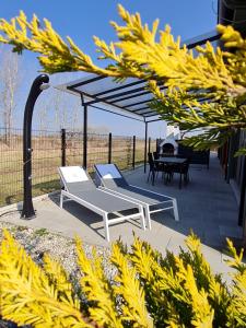 a patio with two chairs and a table and a canopy at Apartmány Betica in Nesvady