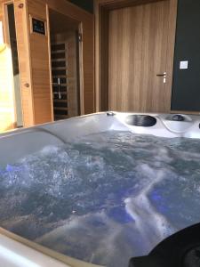 a bath tub filled with water in a bathroom at Apartmány Betica in Nesvady