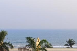 a view of a beach with palm trees and the ocean at Goroomgo Star Inn Puri in Puri