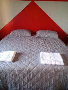 una camera da letto con un letto grande con testiera rossa di ARoss a Ushuaia