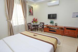 a bedroom with a bed and a desk and a tv at Hotel Sunny HG in Ha Long