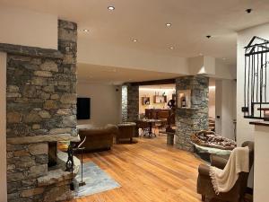 a large living room with a stone fireplace at Raccard Resort de Montagne in Torgnon