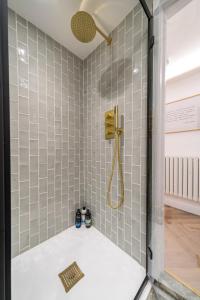 a bathroom with a shower with gray tiles at Luxe Contemporary Cotswold Pad - Heart of Stow in Stow on the Wold