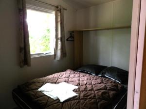 uma cama num quarto com uma janela e um visor de cama em THITOME em Limeuil