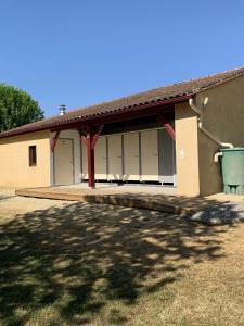 a building with white garage doors and a yard at THITOME in Limeuil