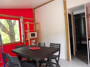 a table and chairs in a room with a red wall at THITOME in Limeuil
