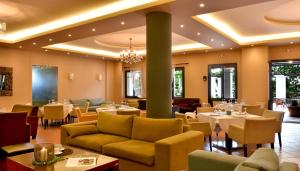 a restaurant with tables and couches and chairs at Hotel Pelion Resort in Portaria