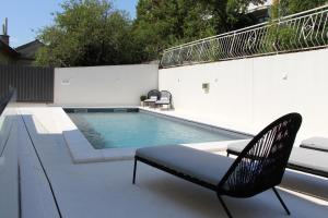 a swimming pool with a bench and a chair at MARIAS in Senj