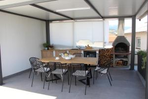 a patio with a table and chairs and a fireplace at MARIAS in Senj