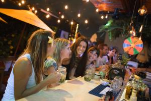 a group of women sitting at a table in a bar at Che Valladolid Hostel & Bar in Valladolid