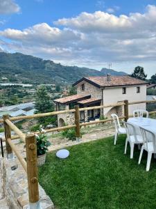einen Garten mit Tisch und Stühlen und ein Haus in der Unterkunft Gli Orti dei Doria di dolceacqua in Dolceacqua