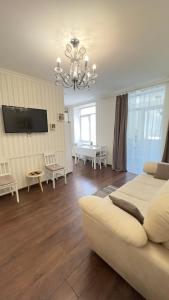 a living room with a white couch and a tv at Apartment in the Centre of City in Dnipro